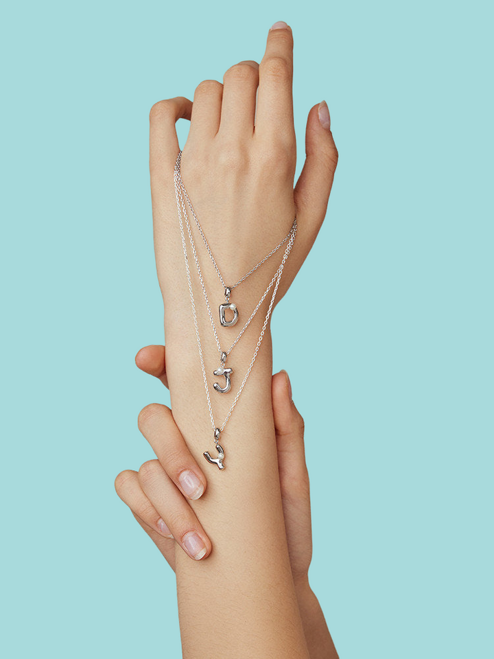 a woman's arm with a stack of jewelry on it