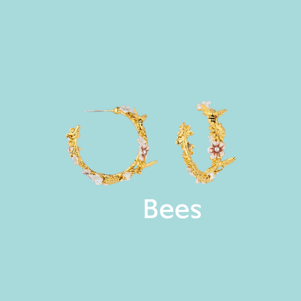 a pair of gold hoop earrings with flowers on them