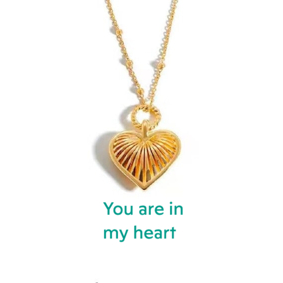 a gold necklace with a heart shaped pendant